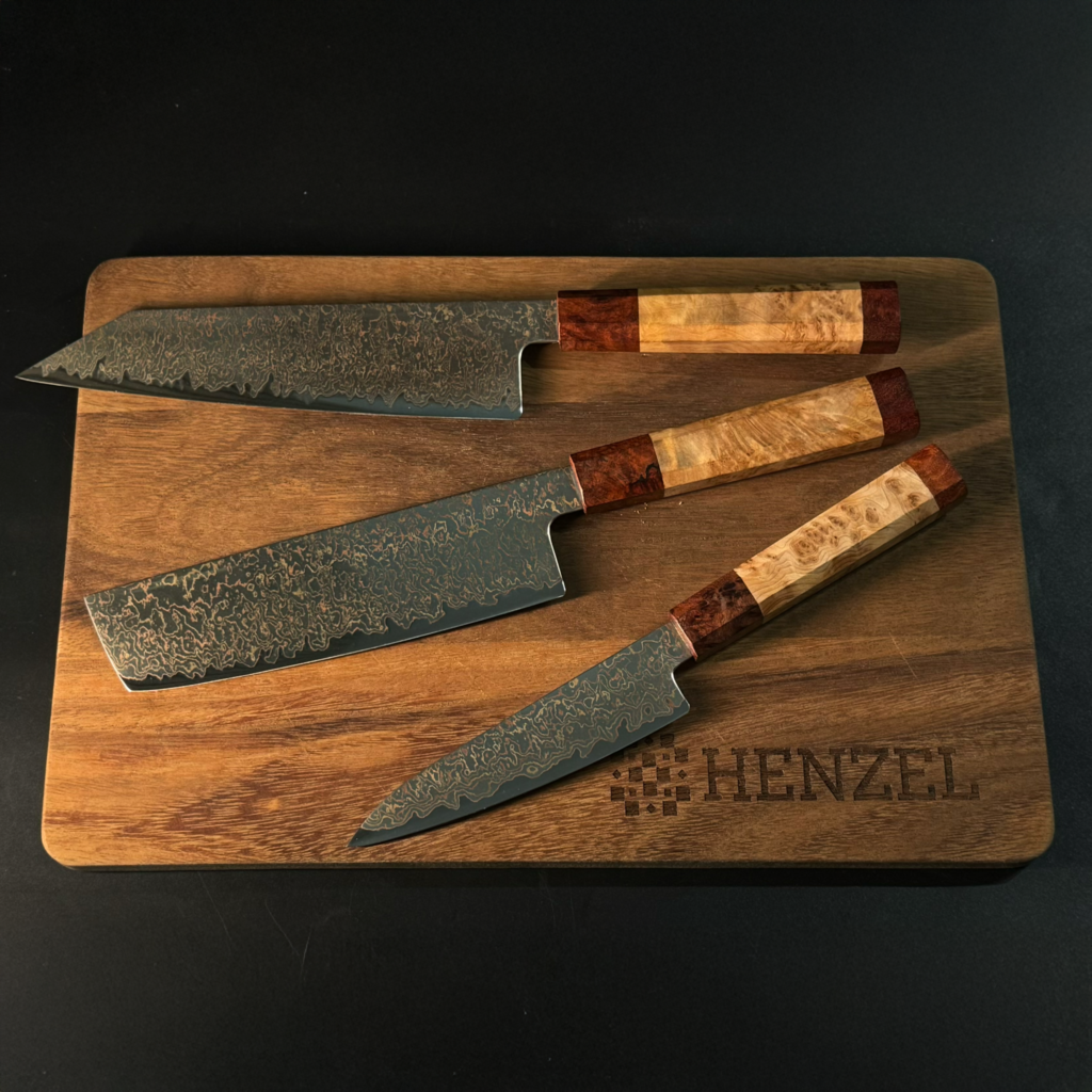 Golden Mirage Knife Set by Henzel - Bunka, Nakiri, and Utility Knives with Damascus Steel and Wood Handles on Cutting Board